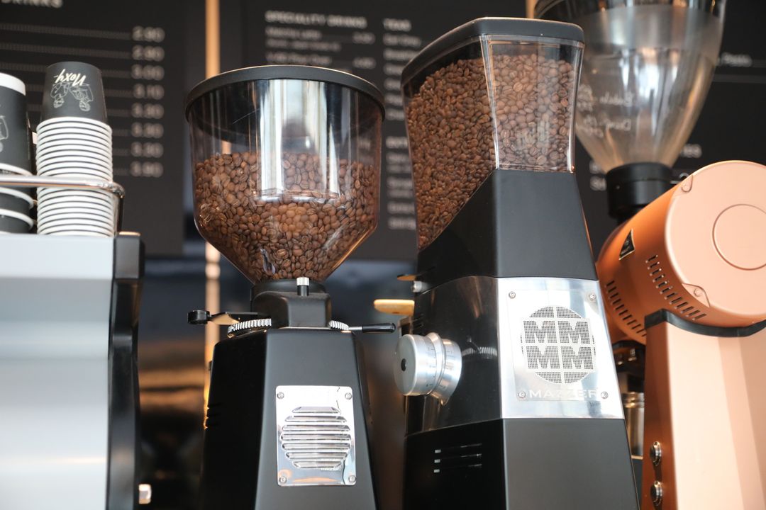Coffee beans in the hopper of a burr grinder.
